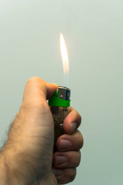 istock hand holding a lighters on white background, high flame on display 1404482637