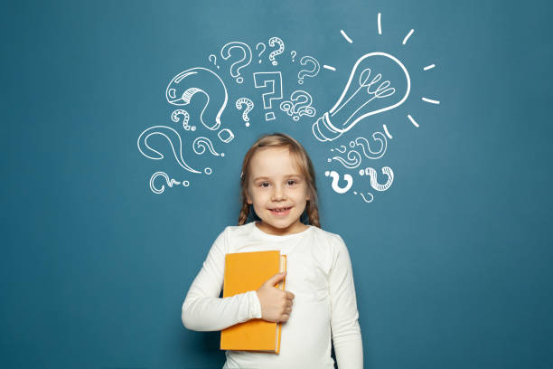 istock Cheerful smiling child school student with yellow book, lightbulb and chalk question marks. Brainstorm, problem and solution 1404483771