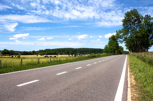 Empty road under blue skies in the rural area of The Ardennes, in Belgium