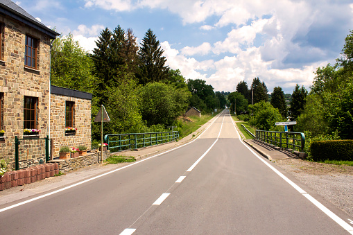 Empty road leads to upper village Le Villetes , in the rural area of the Ardennes in Belgium