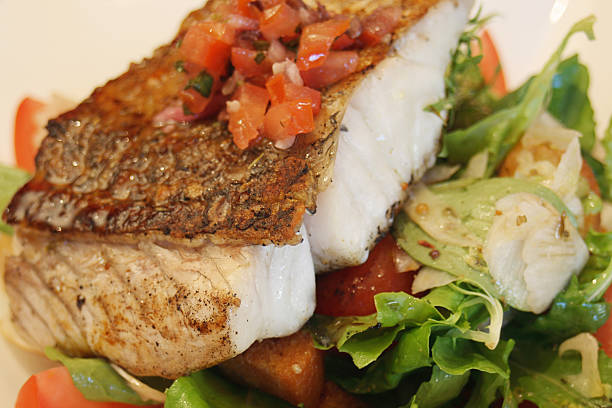 istock Grilled seasoned fish on salad bed 140448491