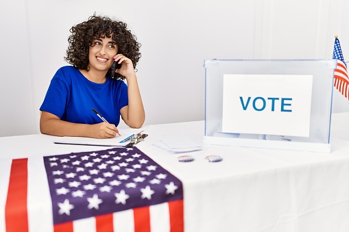 Young middle east woman talking on the smartphone working at electoral college