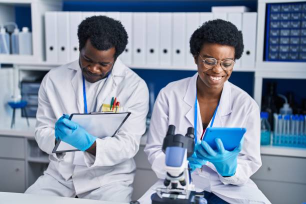 istock African american man and woman scientists using touchpad write on document at laboratory 1404487118