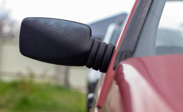 istock Side left right plastic rearview mirror on a red car. Exterior side view mirror on the passenger side on an old car. 1404490500