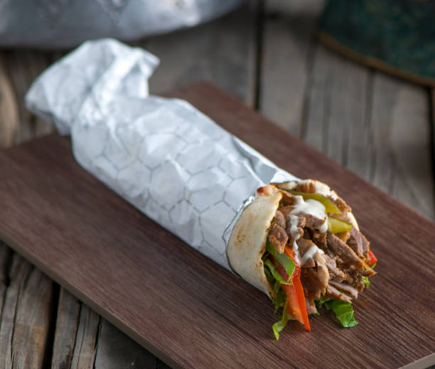 lebanese chicken shawarma served in a dish side view on wooden table background lebanese chicken shawarma served in a dish side view on wooden table background shawarma stock pictures, royalty-free photos & images