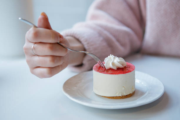 istock Red and white cake being cut with fork in female hand. 1404494366