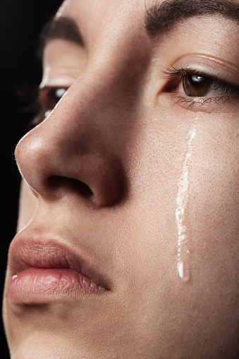 sad woman crying on black background, closeup portrait