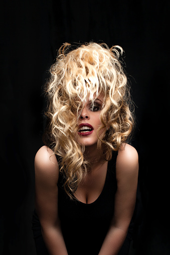 Photo of beautiful blonde woman with magnificent blowing hair with wind motion