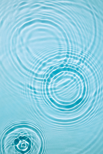 Water background. Blue water texture, blue mint water surface with rings and ripples. Spa concept background. Flat lay, top view, copy space. Raindrops on the surface of the water