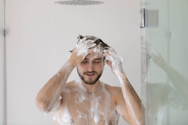 istock Man with foamy head and body taking a shower 1404502058