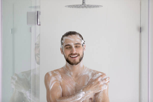 istock Young lathered man take a shower at modern bathroom 1404502062