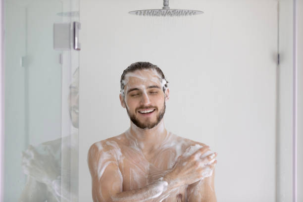 młody spieniony mężczyzna bierze prysznic w nowoczesnej łazience - shirtless caucasian freshness relaxation zdjęcia i obrazy z banku zdjęć