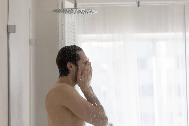 istock Young man washing standing under a stream of running water 1404502070