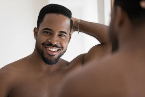 istock Handsome African man pose near mirror smile looks at camera 1404502076