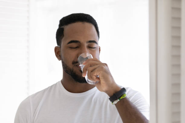 istock African man drinks still water, head shot portrait 1404502166