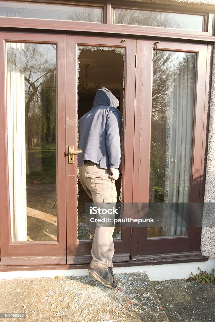 break in! Man entering home through smashed window! Bloody thieves everywhere! I have more crime images, please look through my portfolio. House Stock Photo