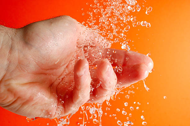 Hand and running water stock photo