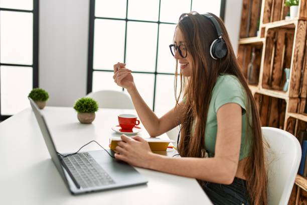 istock Young hispanic woman having video call sitting on table at home 1404503776
