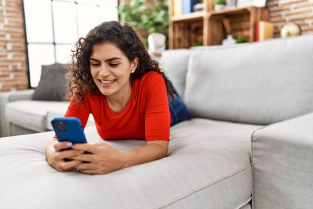 istock Young latin woman smiling confident using smartphone at home 1404504395