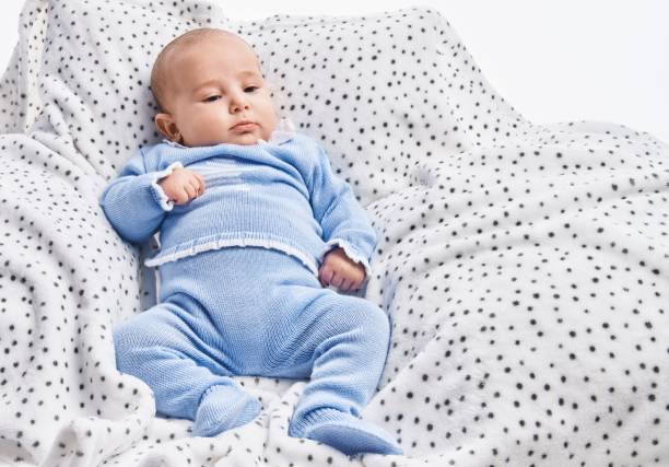Adorable baby relaxed lying on sofa over white isolated background