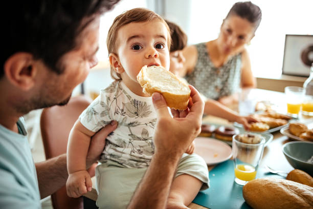 heureux jeune famille - butter bread breakfast table photos et images de collection