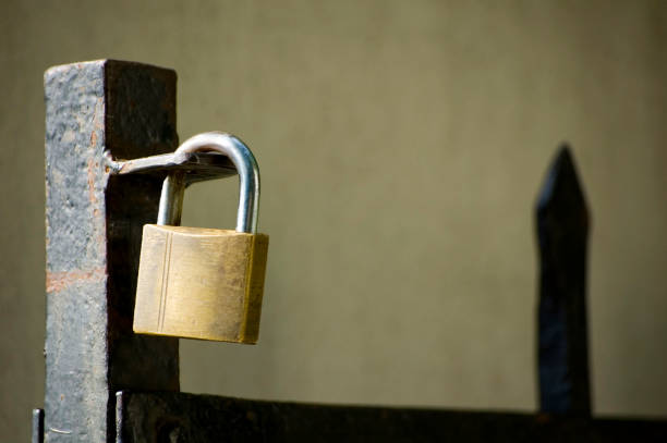 istock Padlock on gate at construction site - lock on closed fence. 1404508280
