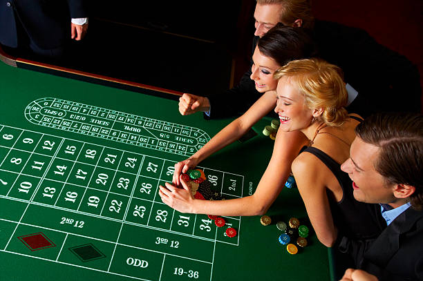 Handsome young roulette dealer spinning the wheel in a casino. Click photo below to view similar gambling images.