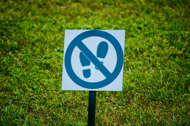 Keep off the grass sign against meadow.