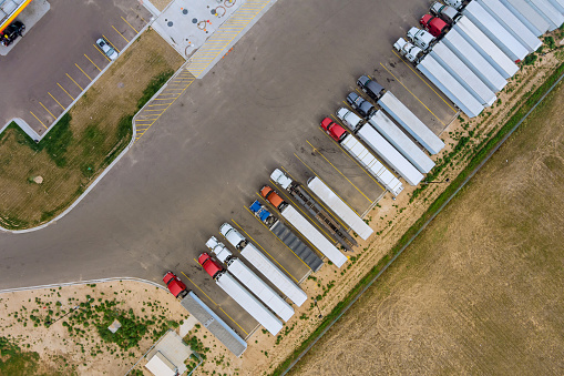 Aerial top view truck stop parking at the rest area on the highway trucks stand in a row