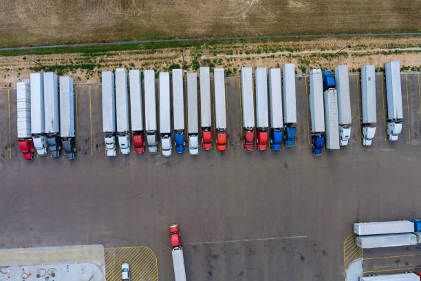 des camions se tiennent en rangée à l’aire de repos sur l’autoroute en vue aérienne - truck parking horizontal shipping photos et images de collection