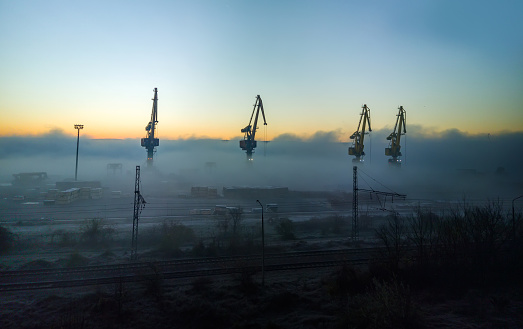 Port cranes shrouded in the morning mist