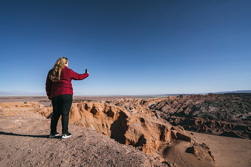 Woman taking pictures of the Atacama Desert