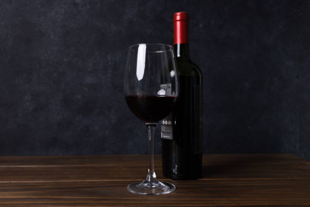istock Wine bottle and glass on dark background 1404512447