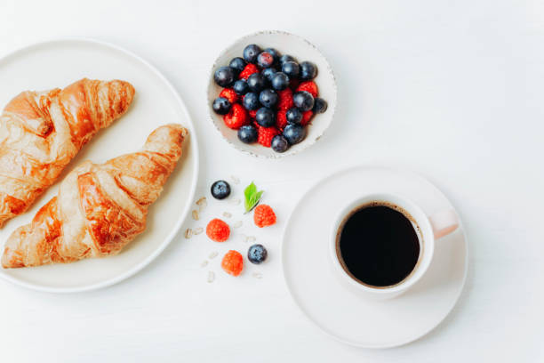 istock Coffee, croissants and berries breakfast on a white table. Top view, flat lay 1404514027