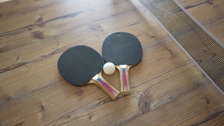 Close up wood table tennis table with racket and ball at home