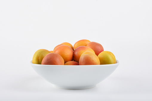 Apricots in a bowl on the white background