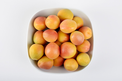 Apricots in a bowl on the white background