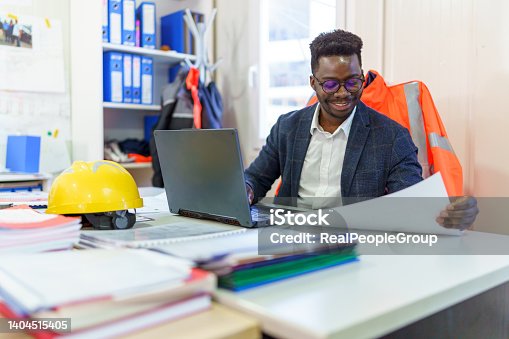 istock Black civil engineer working planning project with laptop. 1404515405