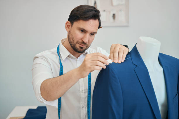 istock Male dressmaker sewing new elegant suit in workshop 1404516538
