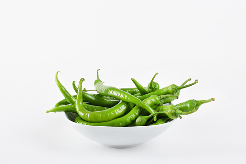 Green peppers vegetable in a bowl on the white background