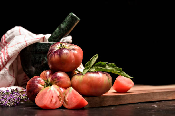 istock Fresh tomatoes in a plate on a dark background. Harvesting tomatoes. Top view. 1404517806