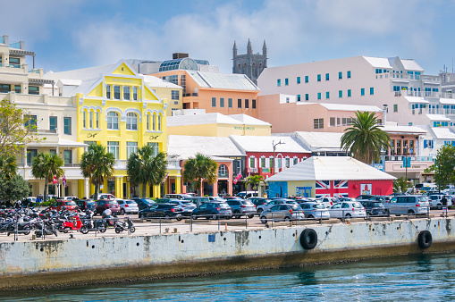 Hamilton, Bermuda-May 24, 2022- Cars and motorcycles park in the parking lot along Front Street in Hamilton. This popular shopping street offers a wide array of high quality, duty free merchandise to visitors.