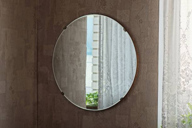 istock one large round glass mirror with reflection hangs on a brown wall 1404522801