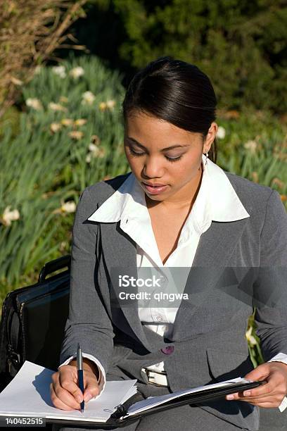 Photo libre de droit de Multiraciale Affaires Écrire Portefeuille Assis Dans Un Parc banque d'images et plus d'images libres de droit de 20-24 ans