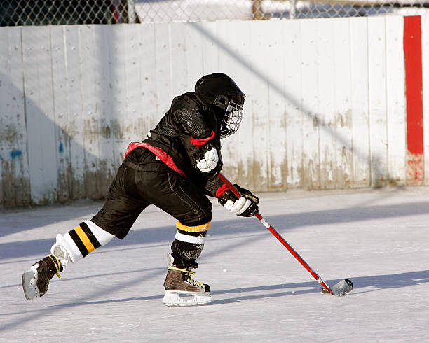 istock Hockey player with full gear and puck on pond 140452795