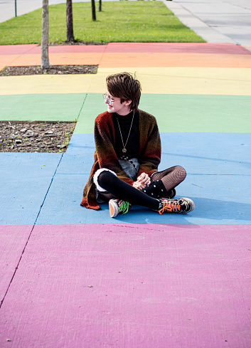 Lgbt tomboy teen representing themselves on a rainbow sidewalk