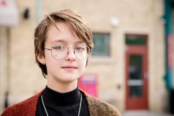 A tomboy with makeup in front of a popular storefront