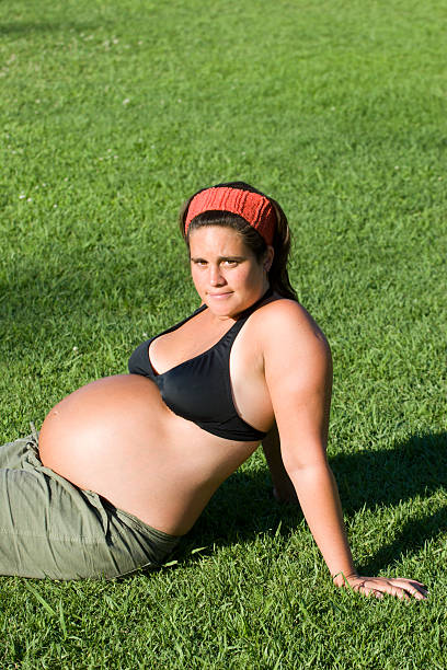 Giovane donna incinta di relax sull'erba - foto stock