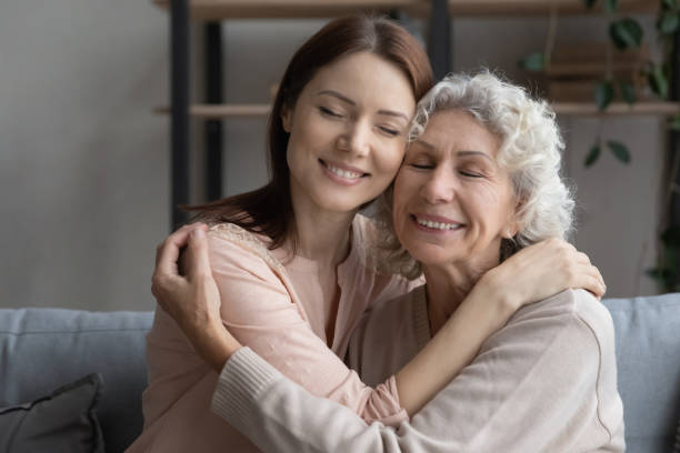 istock Affectionate young woman cuddling older mother at home. 1404530772