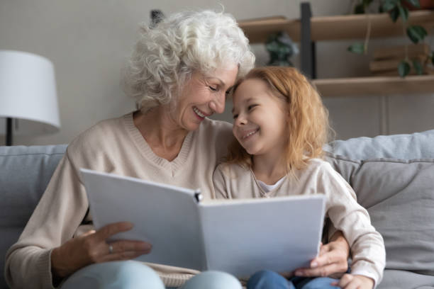 istock Happy old granny reading book with grandchild. 1404531374